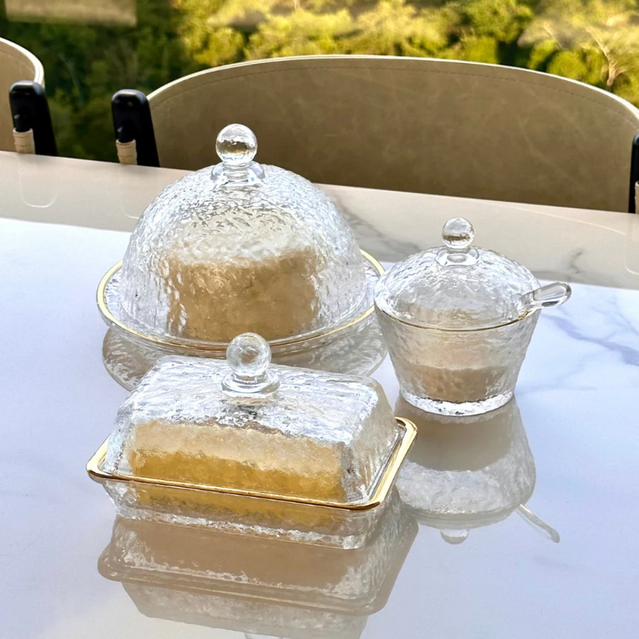 Kit cristal martelado com queijeira manteigueira e acucareiro dourado em mesa
