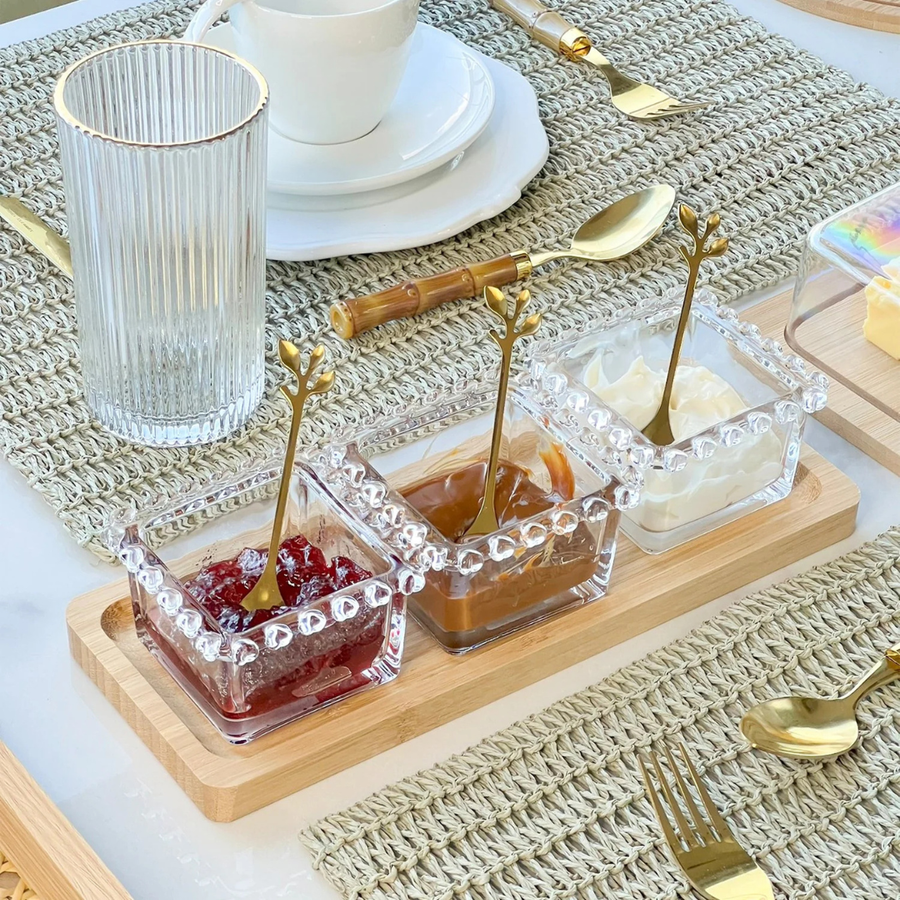 Kit bowls de vidro com geleia e pasta sobre bandeja de madeira em mesa posta