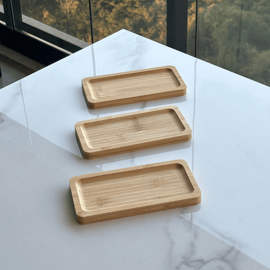 Três petisqueiras de bambu alinhadas verticalmente na mesa