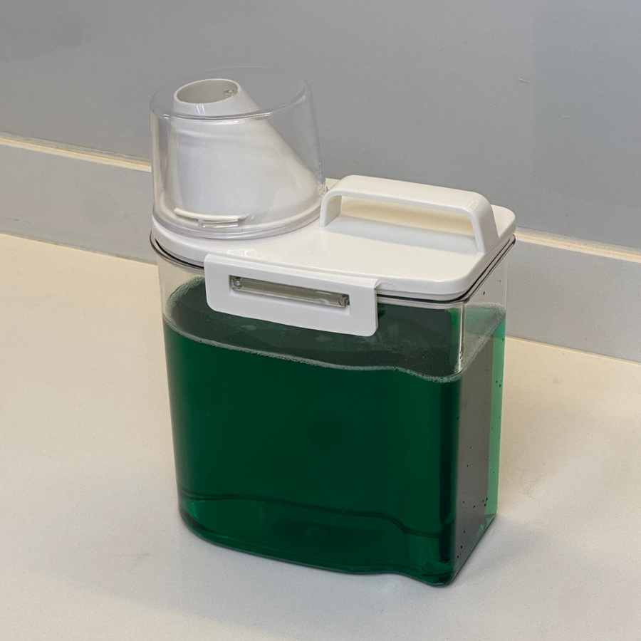 Pote hermetico com liquido verde e trava lateral de seguranca visivel