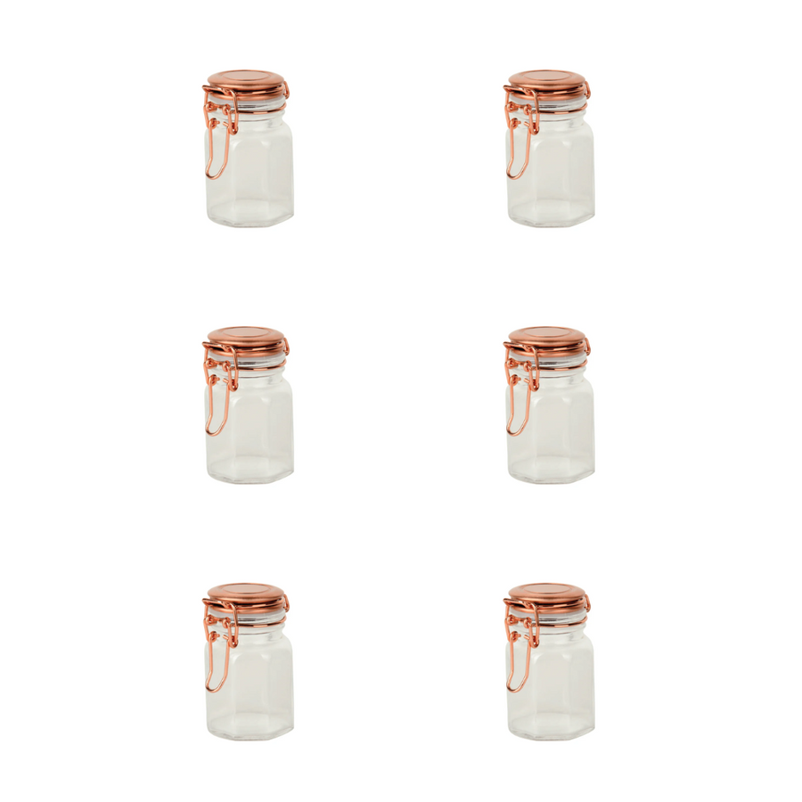 kit com seis potes de vidro vazios e tampas de metal cobre dispostos em grade fundo branco