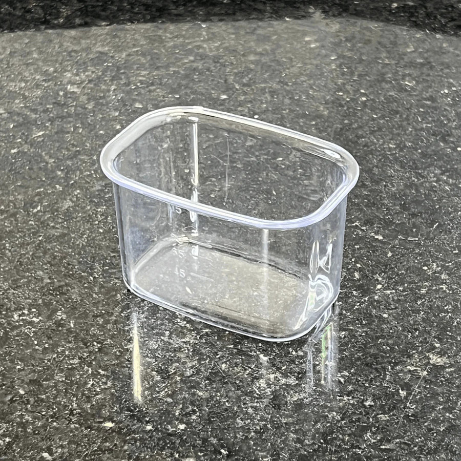 Medidor dosador transparente retangular sobre bancada de granito
