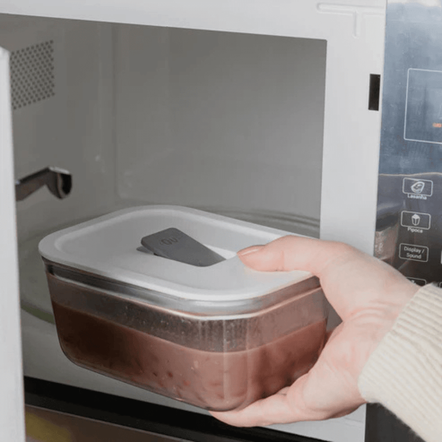 pote hermético de vidro sendo colocado no micro-ondas com comida dentro