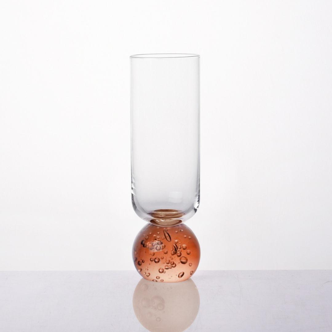 Detalhe da base esférica âmbar com bolhas na taça champanhe