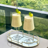 Taças com bebida gelada e hortelã em mesa de varanda