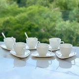 Jogo seis xicaras de cafe em porcelana branca com pires e colher sobre mesa
